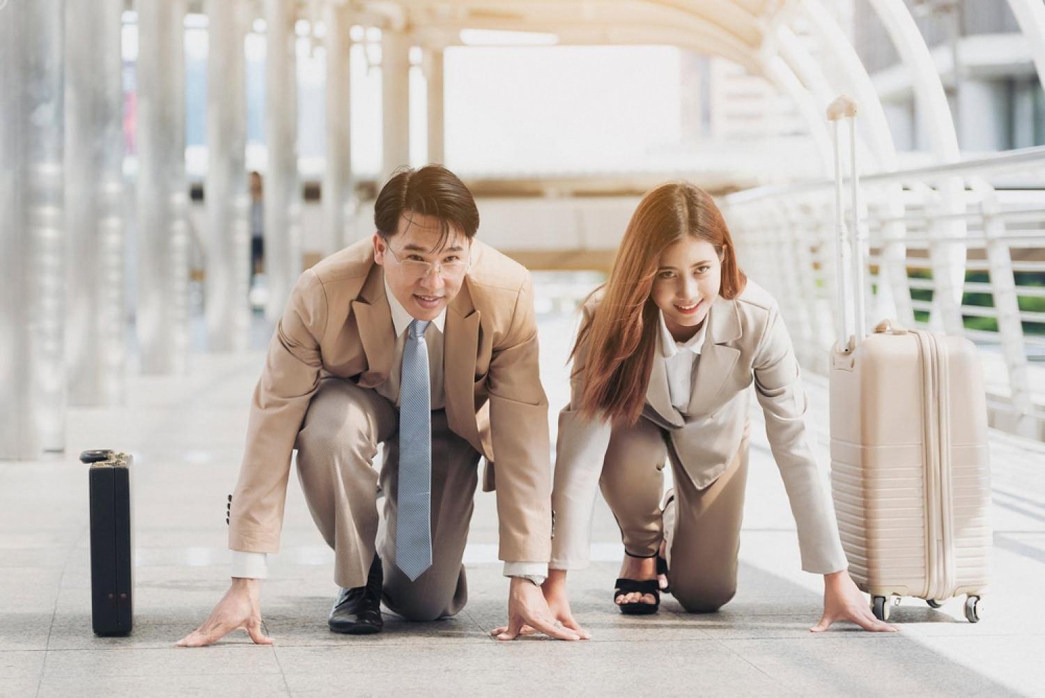 Two professionals in starting-line pose on a Dubai walkway, ready for a new career step